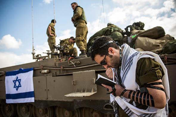 An Israeli reservist troop prays near the Israeli-Gaza border on the morning of July 18, 2014 near Sderot, Israel.