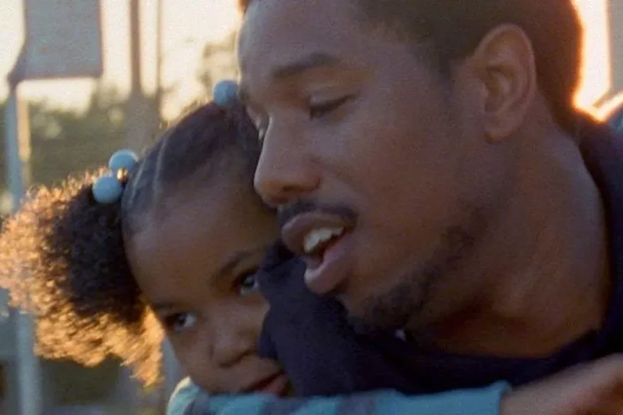 A little girl holding her arms around her dad.