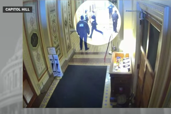 Josh Hawley, spotlighted in a white circle, can be seen running daintily from one side of a hallway to the other on security camera footage.