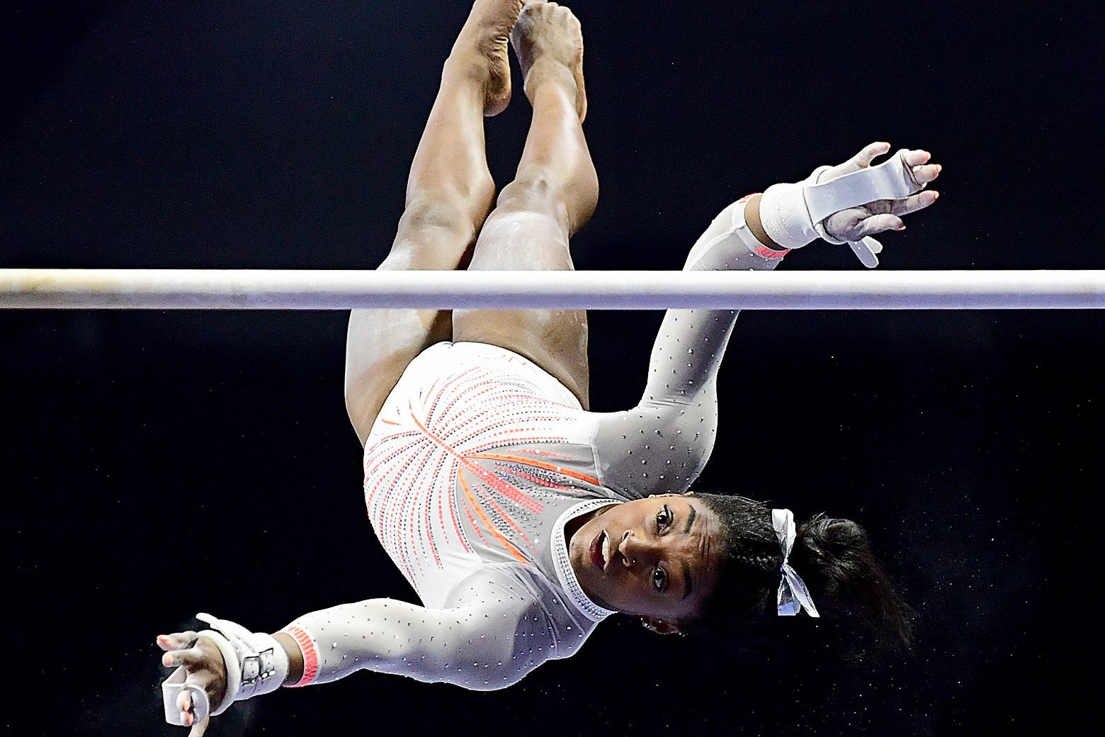 Simone Biles flipping upside-down during her uneven bars routine