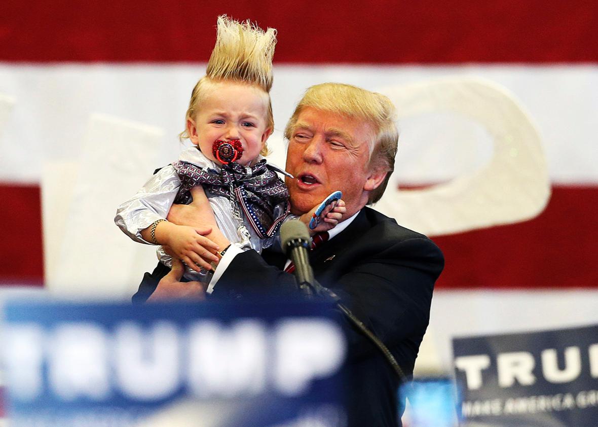 Republican U.S. presidential candidate Donald Trump holds up a crying young child from the crowd as he arrives at a Trump campaign rally in New Orleans, Louisiana March 4, 2016.   