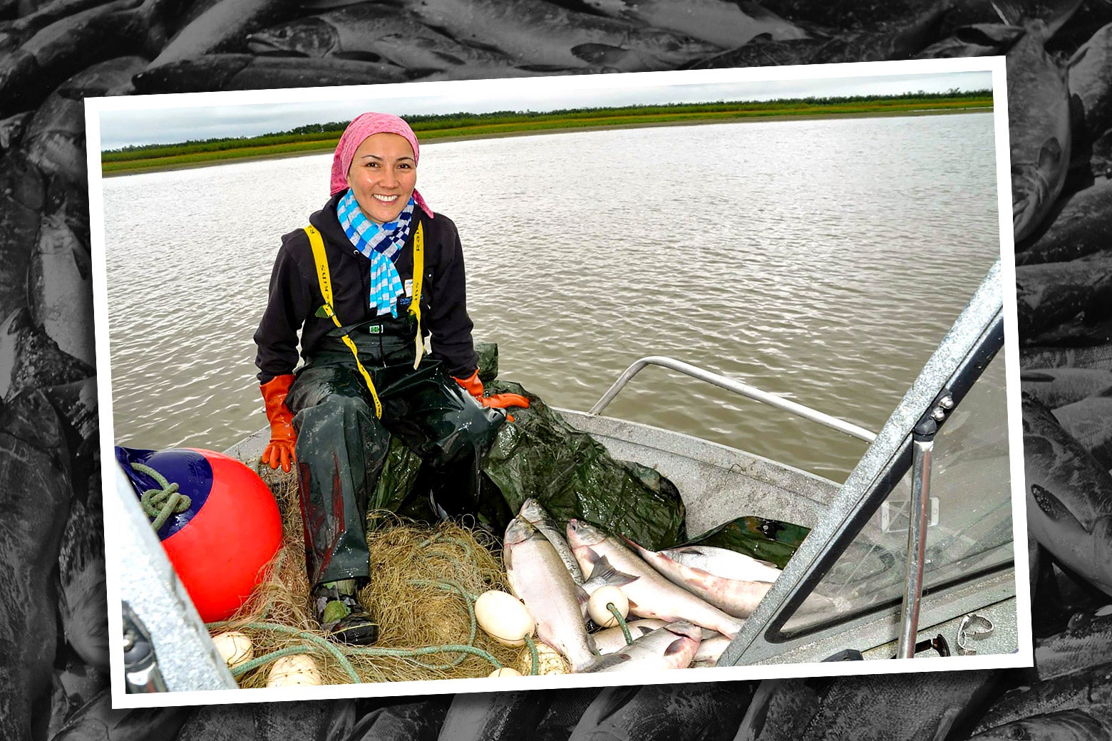 Mary Peltola sits smiling in a boat on the water, with a pile of fish at her feet.