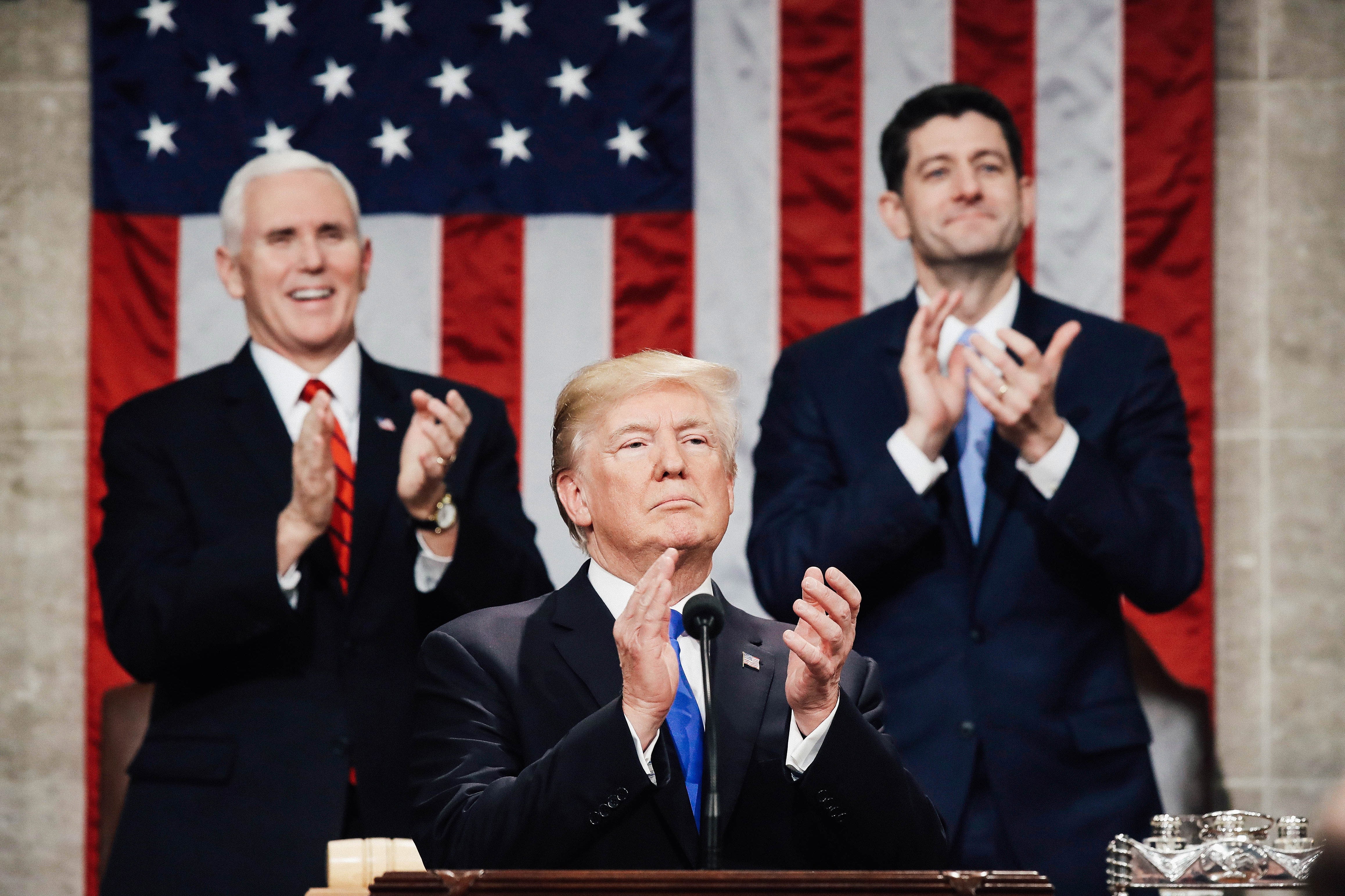 U.S. President Donald J. Trump claps along with U.S. Vice President Mike Pence (L) and Speaker of the House U.S. Rep. Paul Ryan (R-WI) (R) during the State of the Union address.