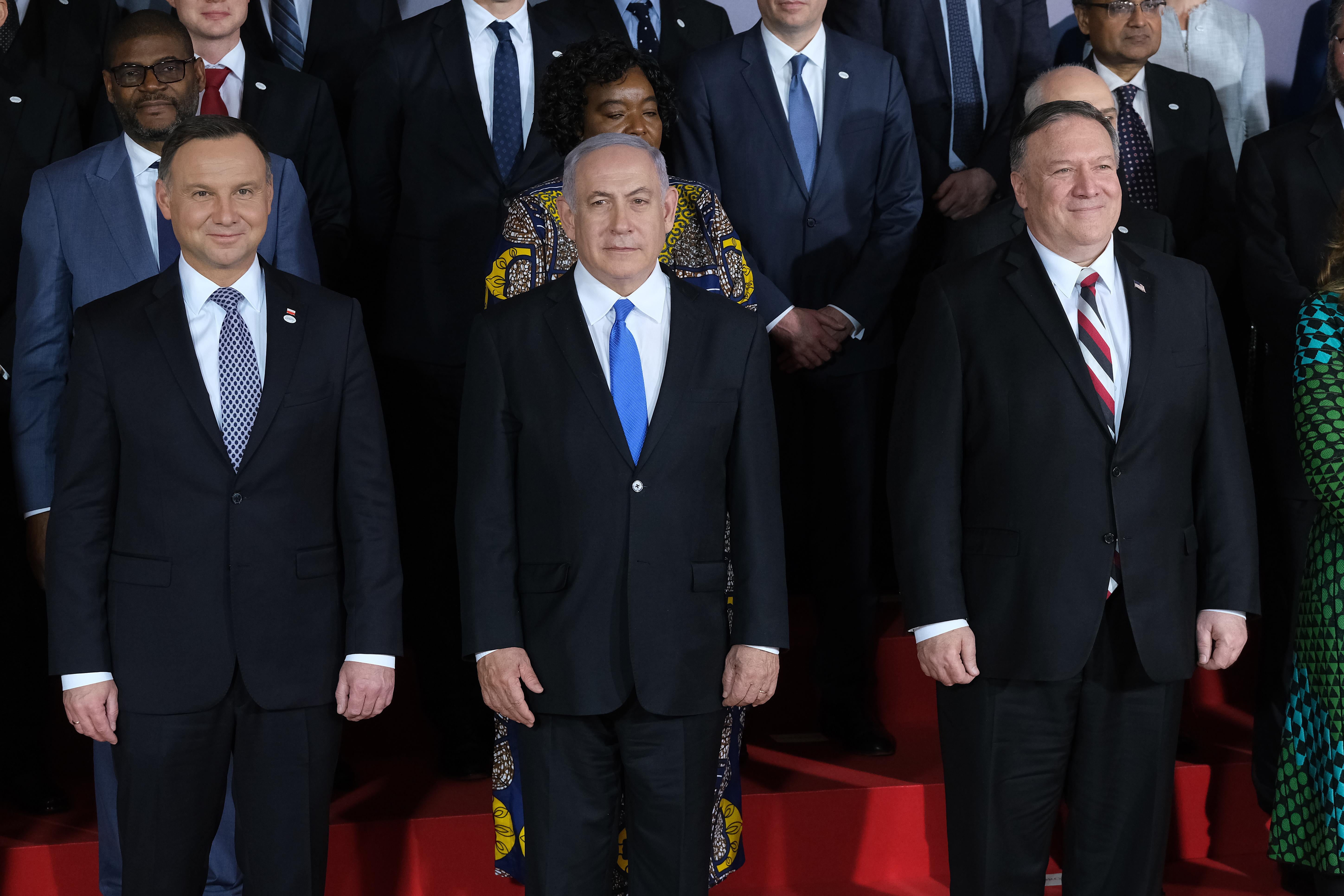 Andrzej Duda, Benjamin Netanyahu, and Mike Pompeo wearing suits and posing for a group photo.