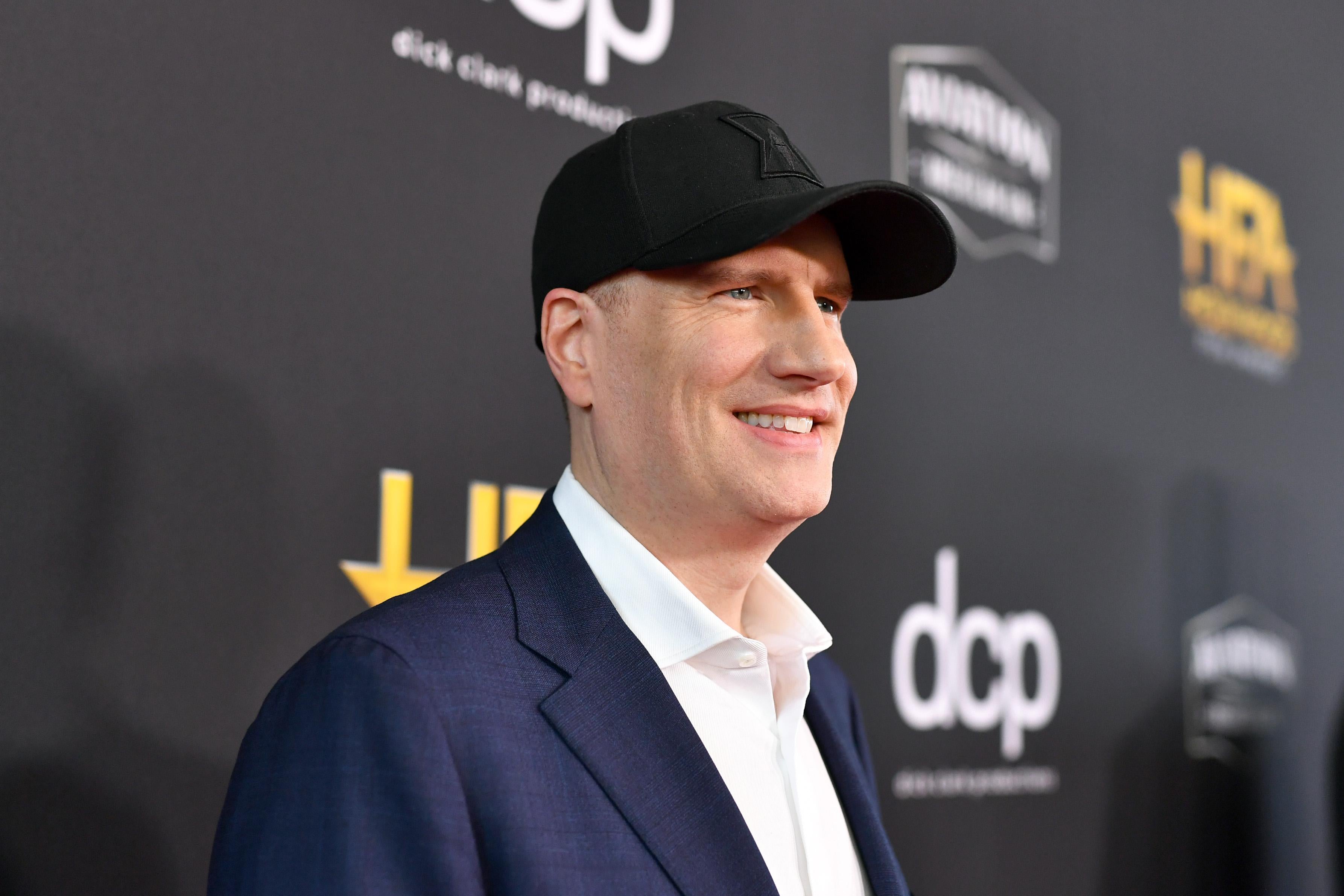 Kevin Feige on a red carpet, wearing a baseball hat.