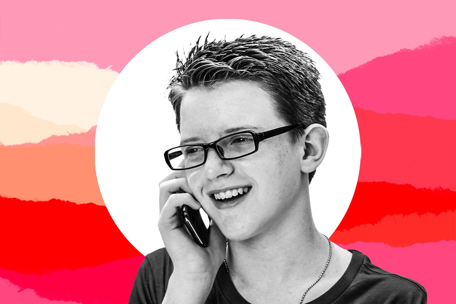 Young teen boy smiling while on the phone.
