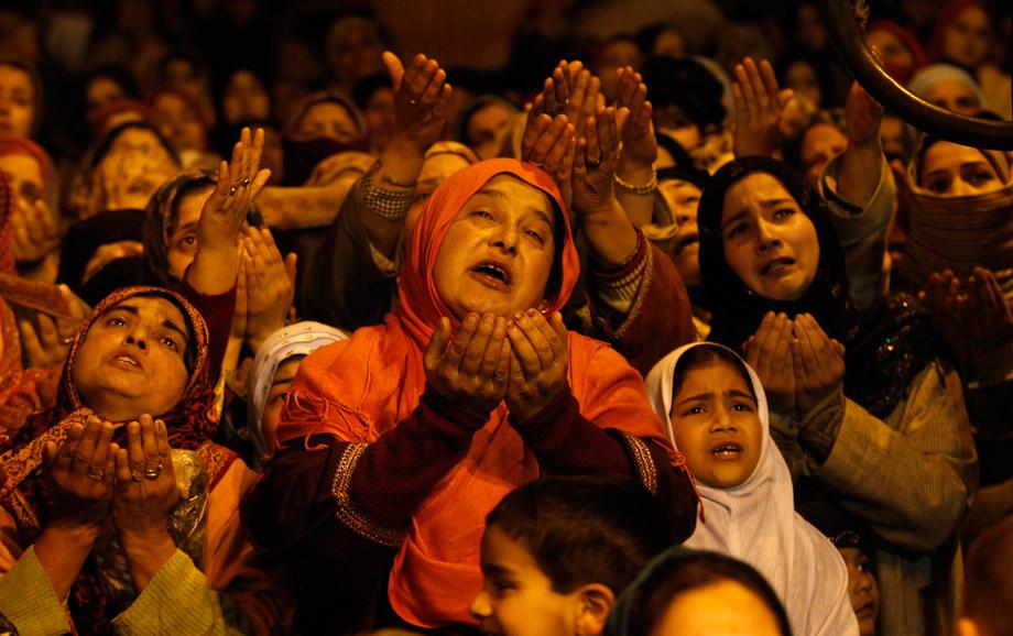 Kashmiri Muslims raise their arms upon seeing a relic of Sheikh Abdul Qadir Jeelani, a Sufi saint, being displayed to devotees during the Friday following at his shrine in Srinagar March 1, 2013. 