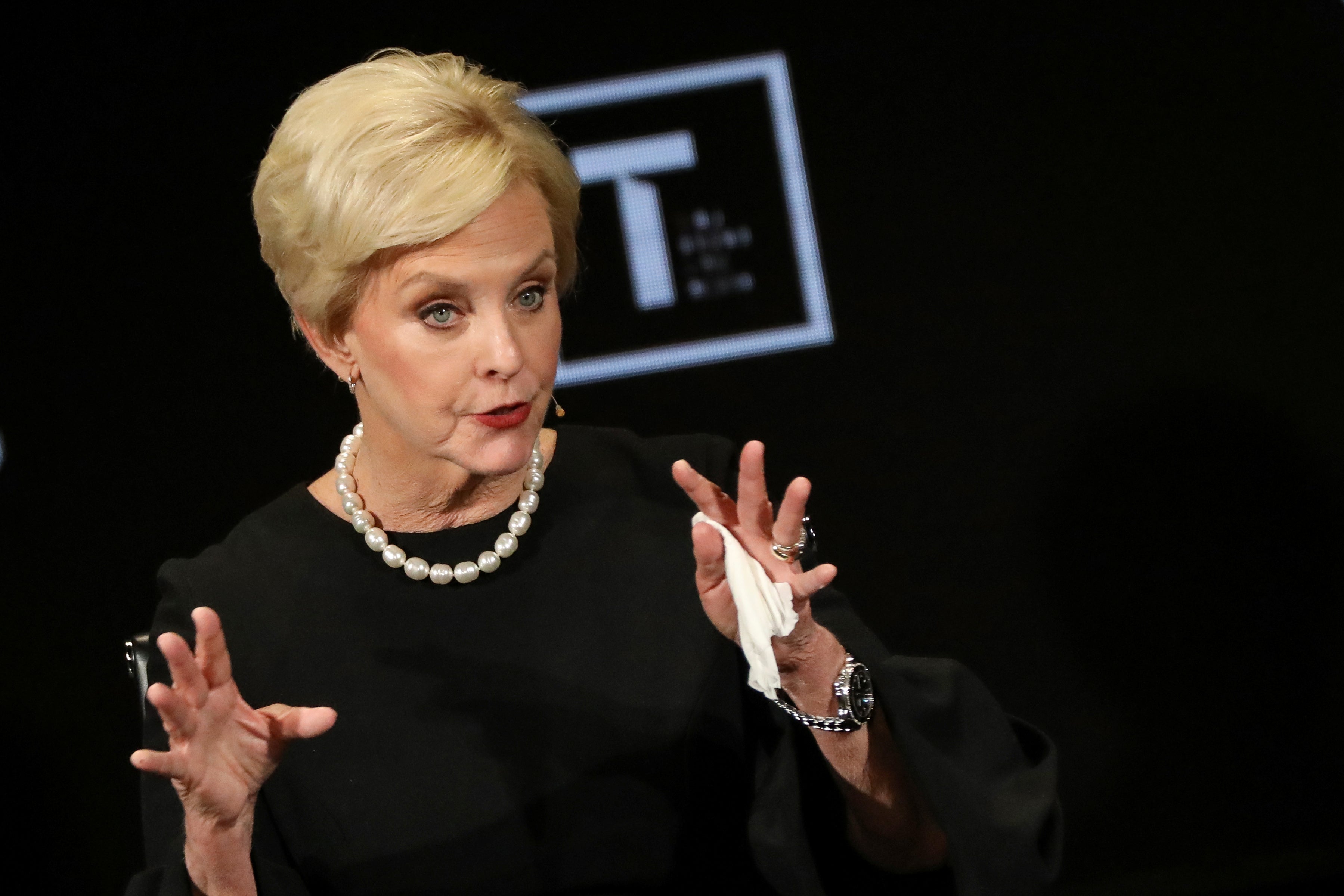 Cindy McCain gestures with both hands while speaking onstage