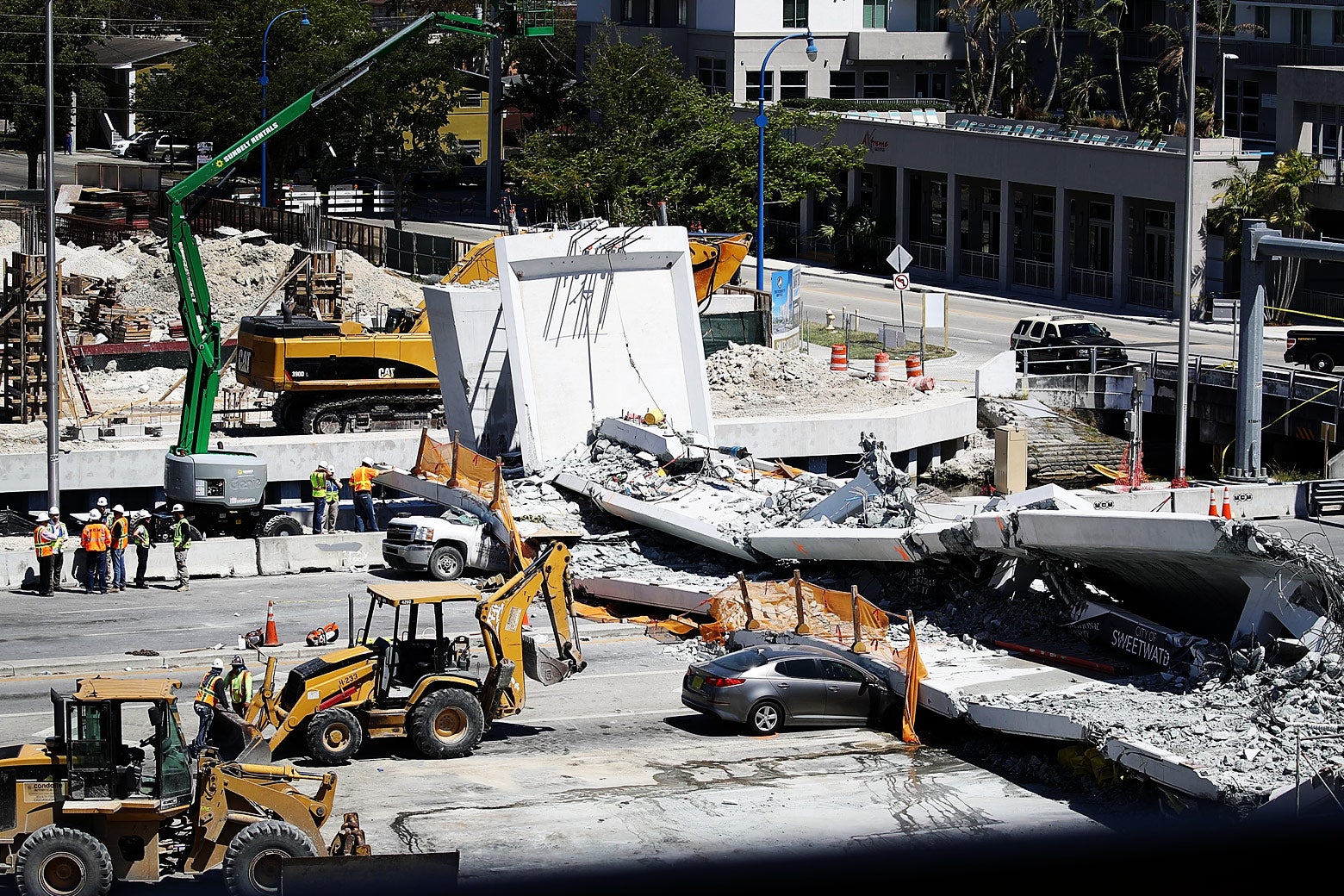 Law enforcement and members of the National Transportation Safety Board investigate the scene where a pedestrian bridge collapsed a few days in Miami, Florida.