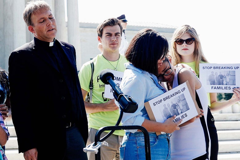 The Rev. Seth Kaper-Dale looks on as sisters Michelle Edralin, 12, and Nicole Edralin, 15, react with immigration rights proponents outside the U.S. Supreme Court after it upheld President Donald Trump's travel ban on Tuesday.