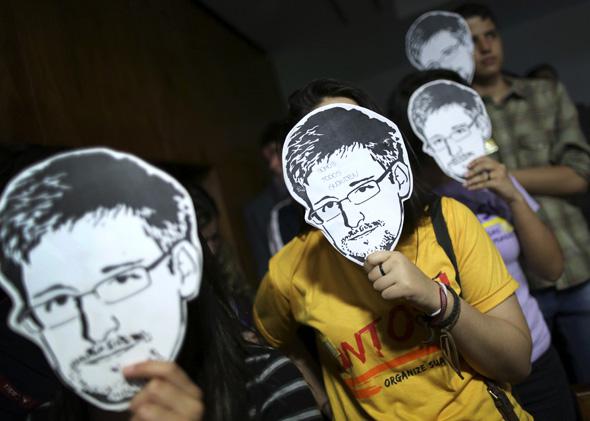 People use masks with pictures of former NSA contractor Edward Snowden masks during the testimonial of Glenn Greenwald.