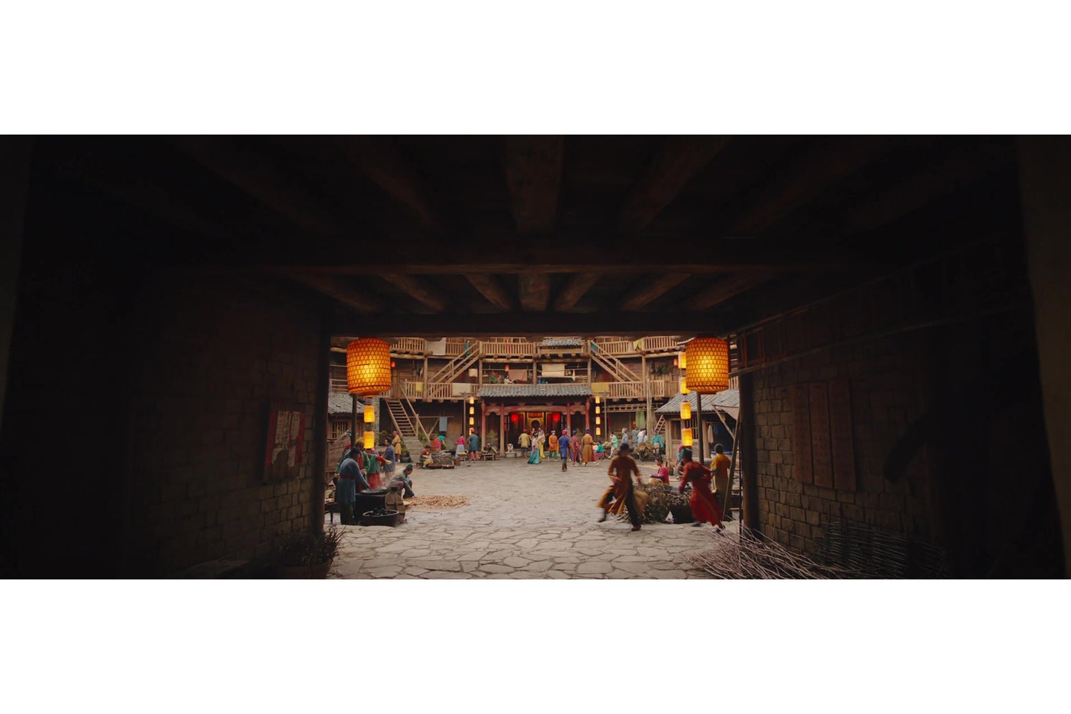 A dark entry corridor leading into a brightly-lit courtyard.