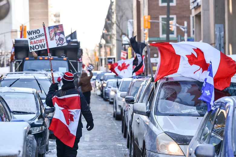 A protester of the vaccine mandates introduced by Canadian Prime Minister Justin Trudeau walks down Metcalfe Street draped in a Canadian flag on February 5, 2022 in Ottawa, Canada. 