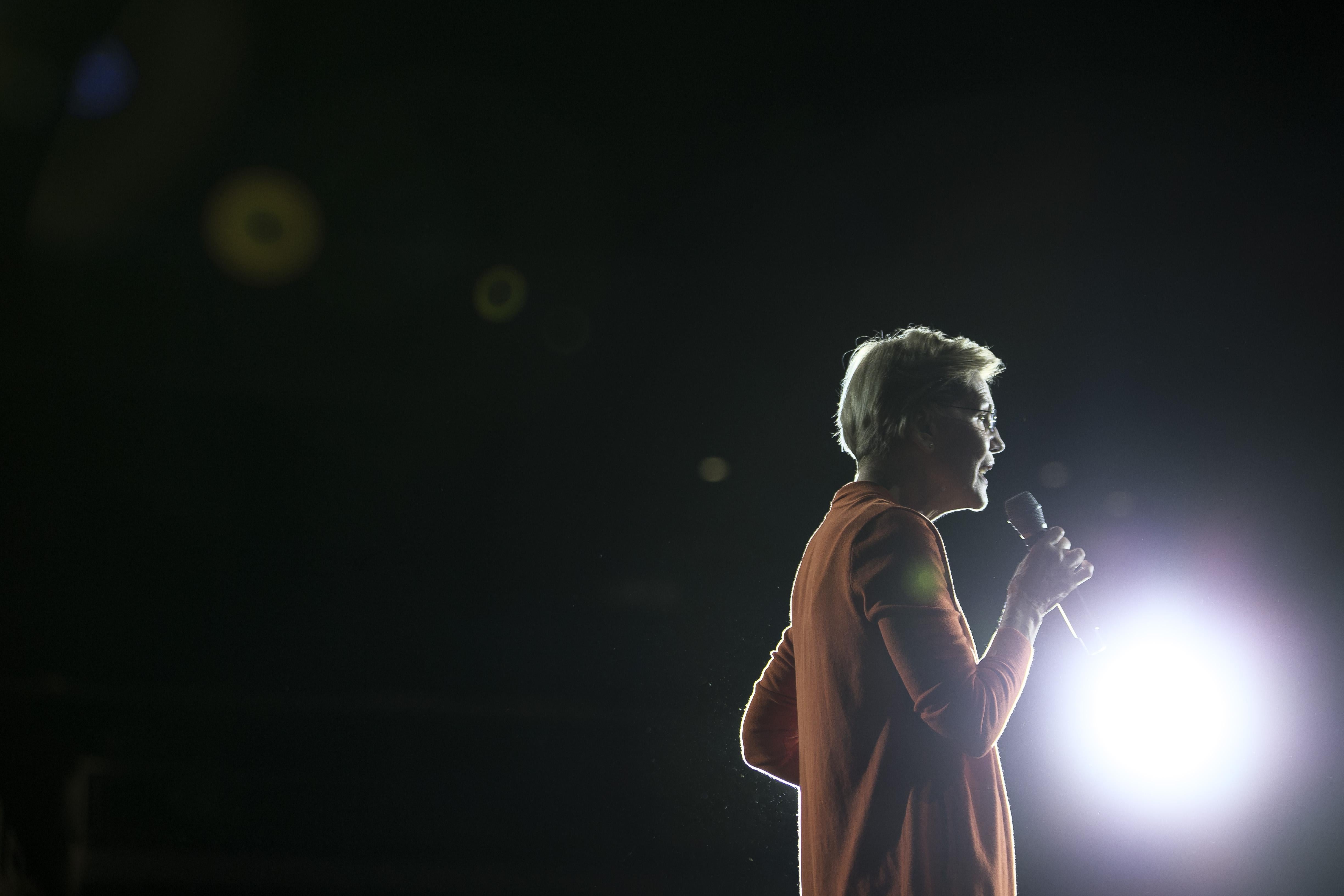 Elizabeth Warren speaks into a mic in front of a bright light onstage at a town hall event on Oct. 18 in Norfolk, Virginia.