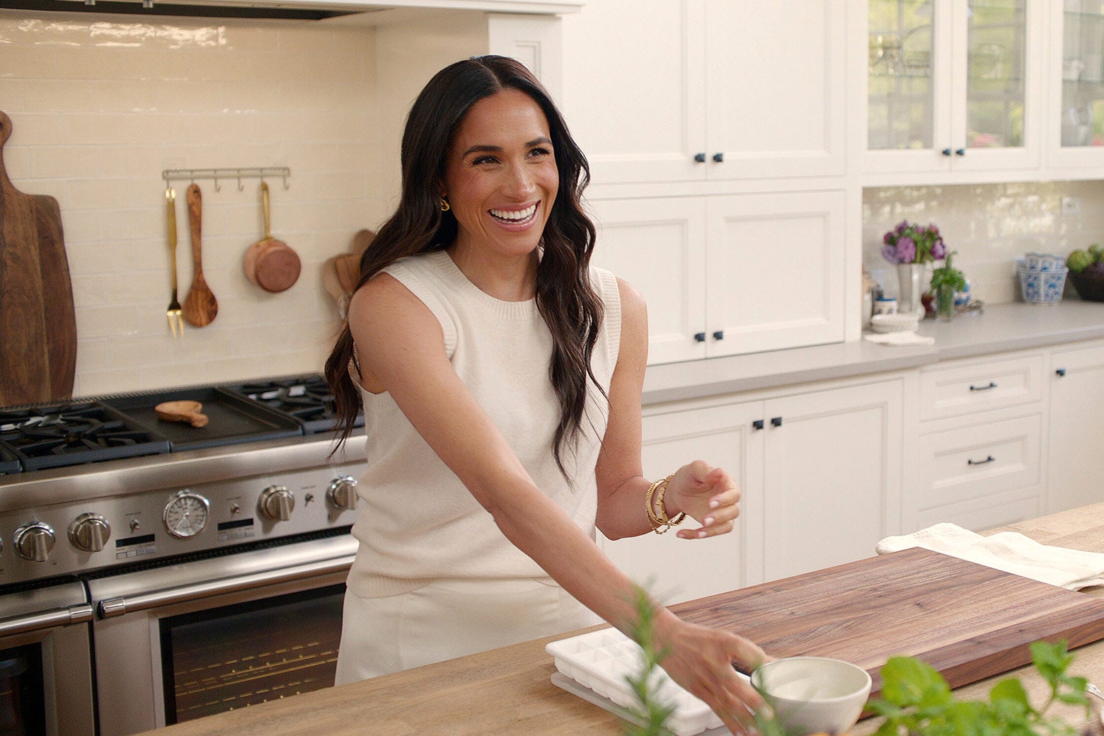 Meghan, Duchess of Sussex, in a neutral-toned, nice kitchen.