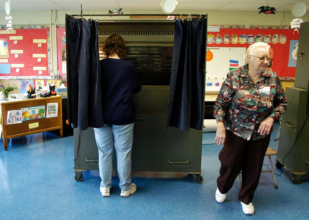 Janet Conaway prepares to close the curtain and cast her ballot in a voting booth as poll worker Ruth Annan stands by for assistance at a polling place November 2, 2004 in Southampton, Pennsylvania. 