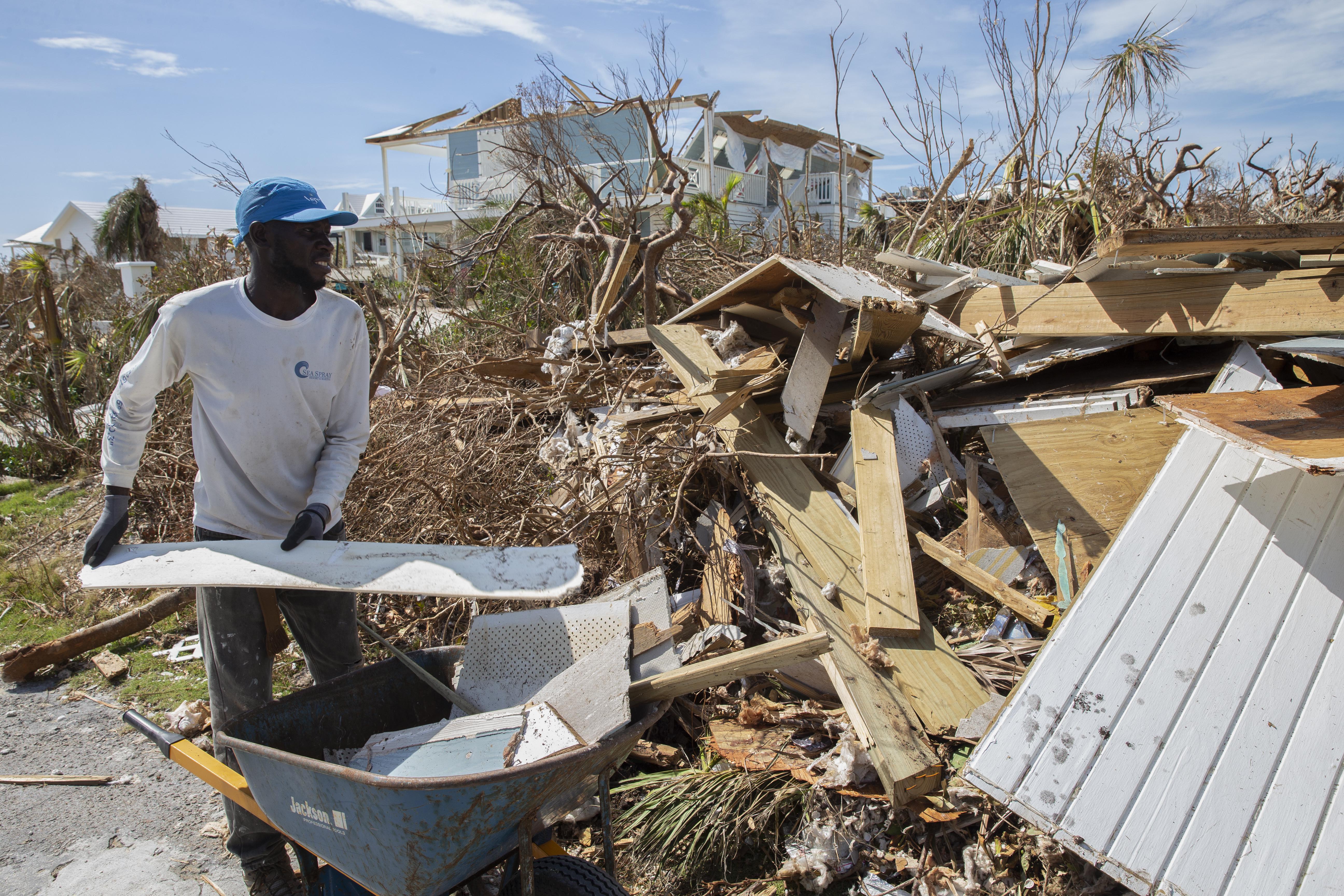 A resident collects rubble and debris from damaged homes after Hurricane Dorian devastated Elbow Key Island.