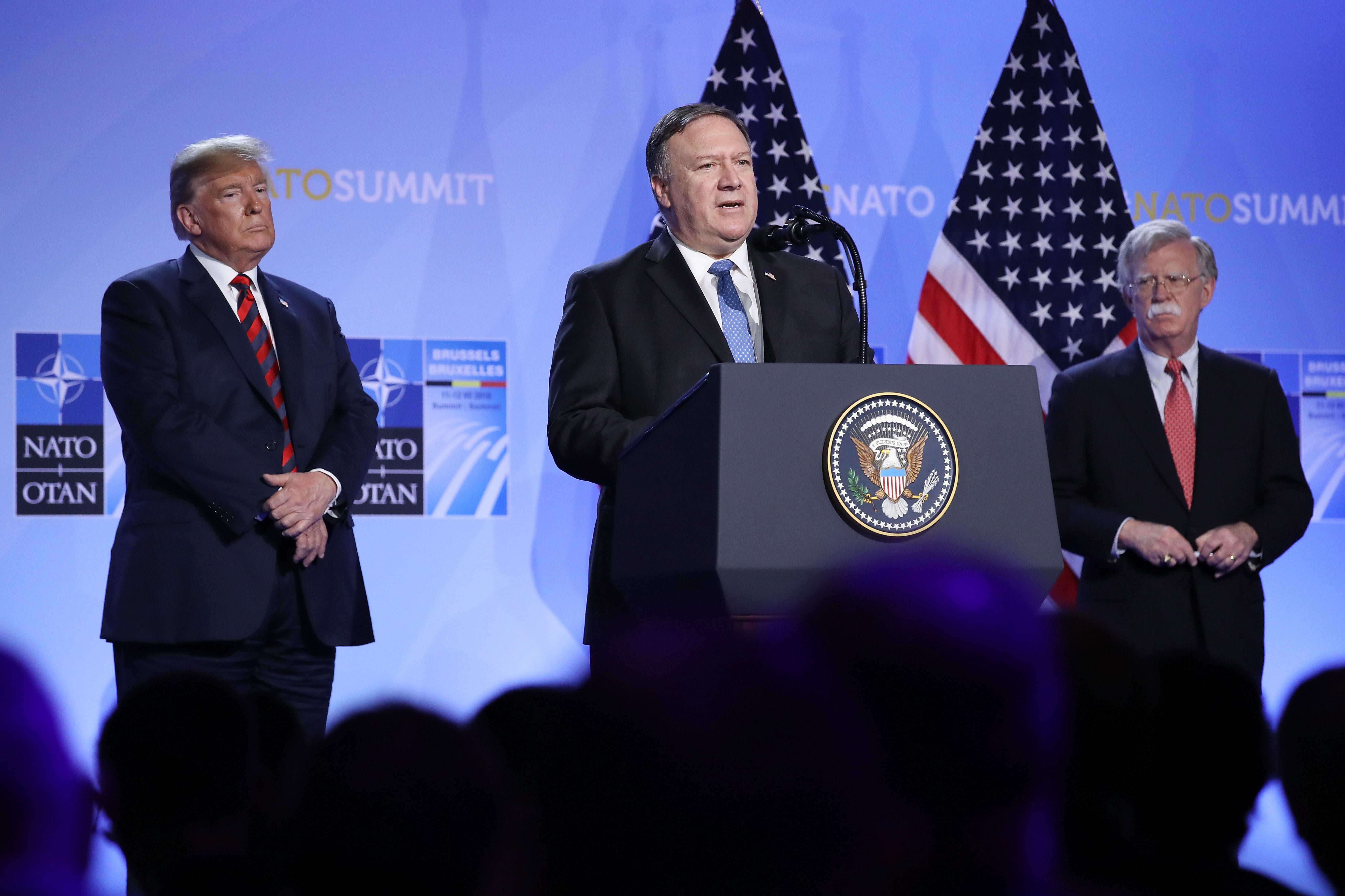 U.S. President Donald Trump (L) and National Security Advisor John Bolton (R) look on as U.S. Secretary of State Mike Pompeo speaks briefly to the media at a press conference on the second day of the 2018 NATO Summit on July 12, 2018 in Brussels, Belgium.