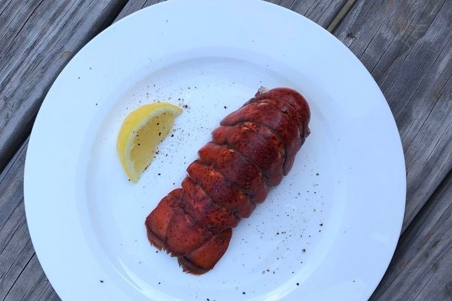 Cooked lobster tail shell up on a plate.