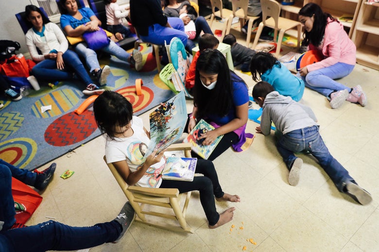 Children read and draw in a playroom as moms look on