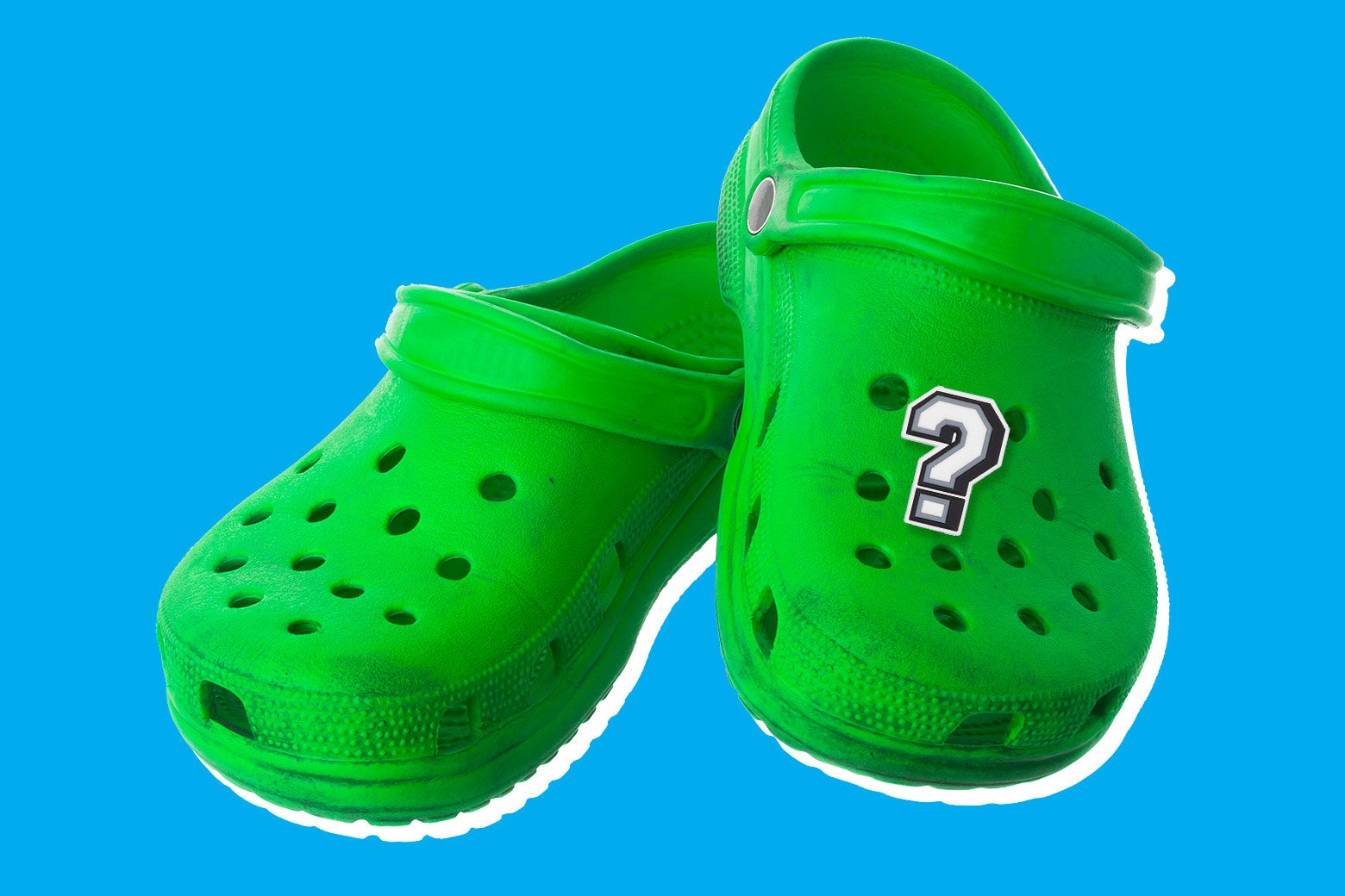 A pair of green Croc clogs with a question-mark button.