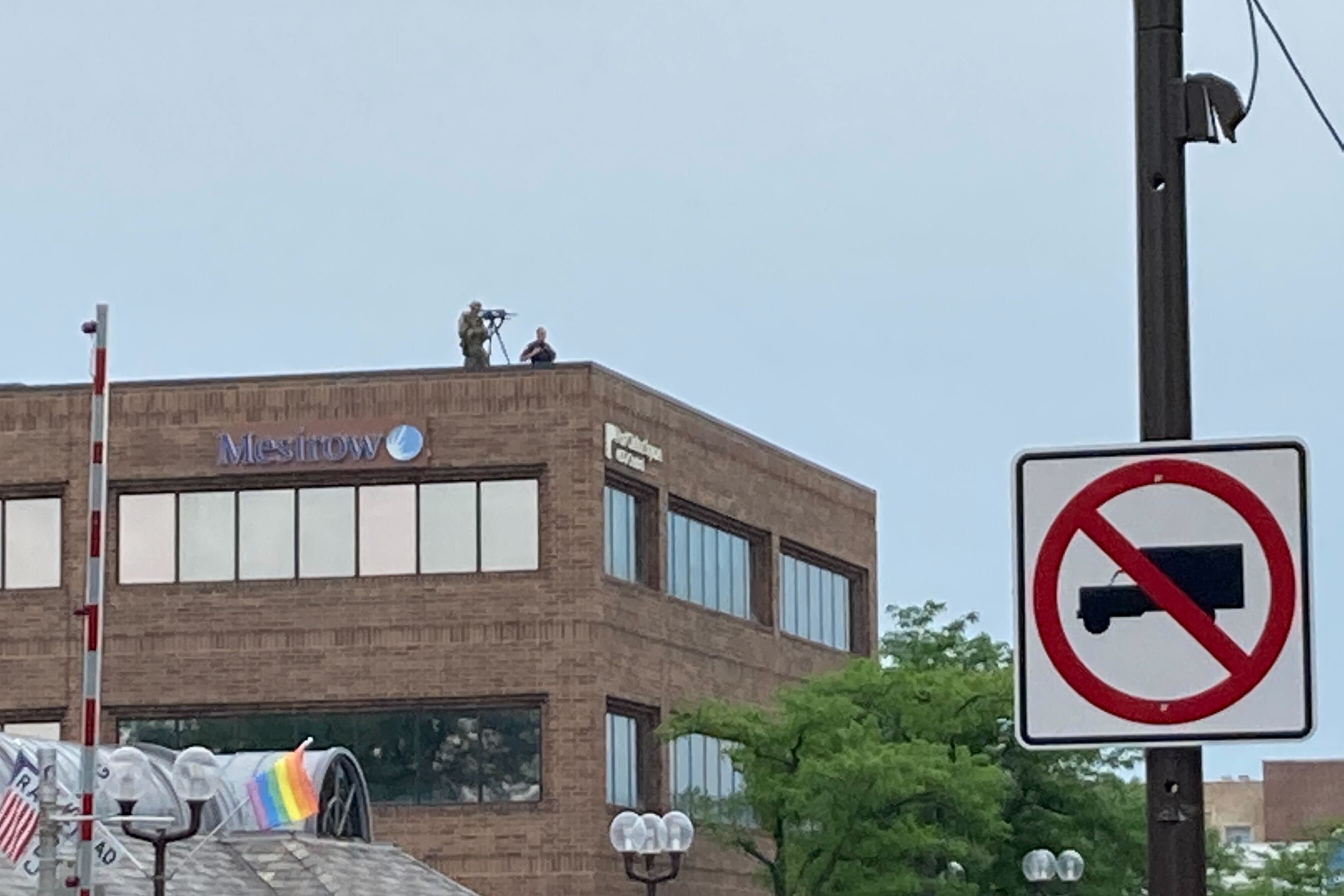 A sniper sets up on the roof of Port Clinton Square in downtown Highland Park.