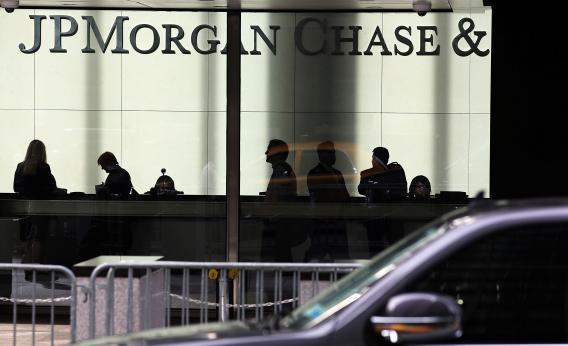People pass a sign for JPMorgan Chase & Co. at its headquarters in Manhattan on Oct. 2, 2012, in New York City.