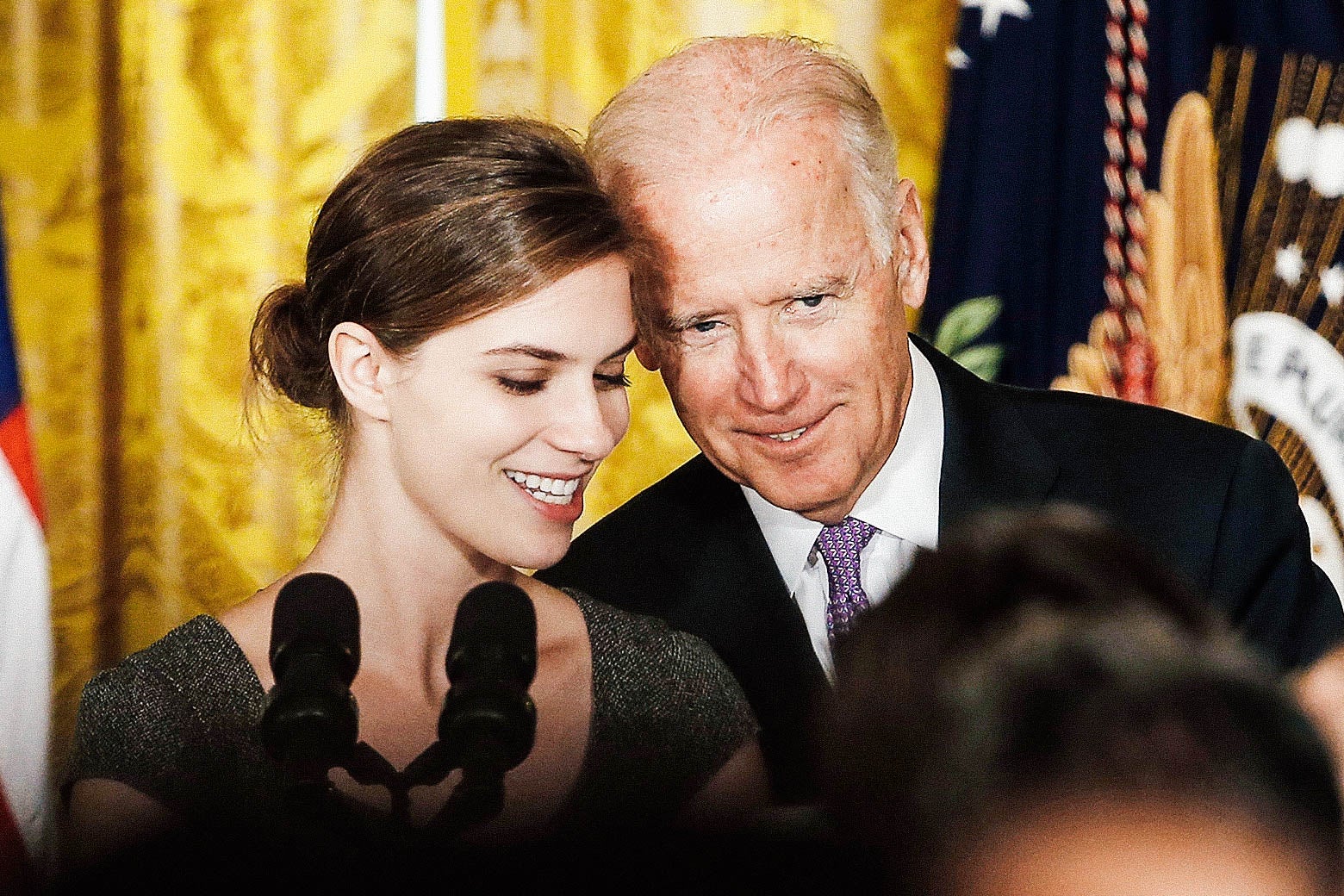 Lilly Jay, a survivor of sexual assault, stands with Vice President Joe Biden at the launch of the “It’s On Us” campaign at the White House on Sept. 19, 2014. Biden is leaning close enough that his head is almost touching Jay's.