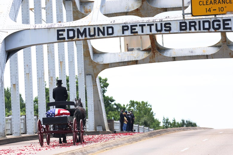 A horse-drawn carriage carrying the body of civil rights icon, former US Rep. John Lewis (D-GA) crosses the Edmund Pettus Bridge as it prepares to pass members of his family on July 26, 2020 in Selma, Alabama.