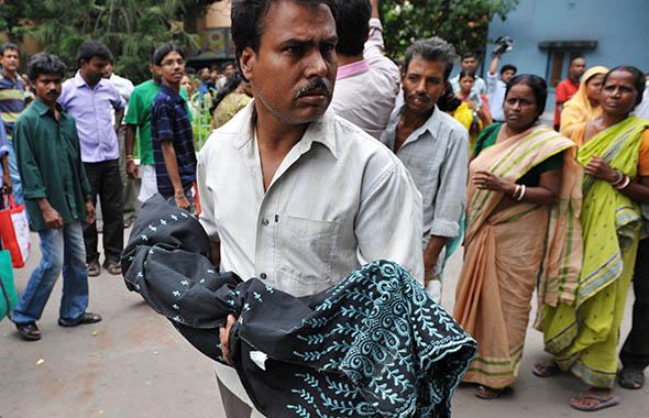 A relative carries the body of a newborn child from the Dr. B.C. Roy Memorial Hospital for Children in Kolkata on June 30, 2011.
