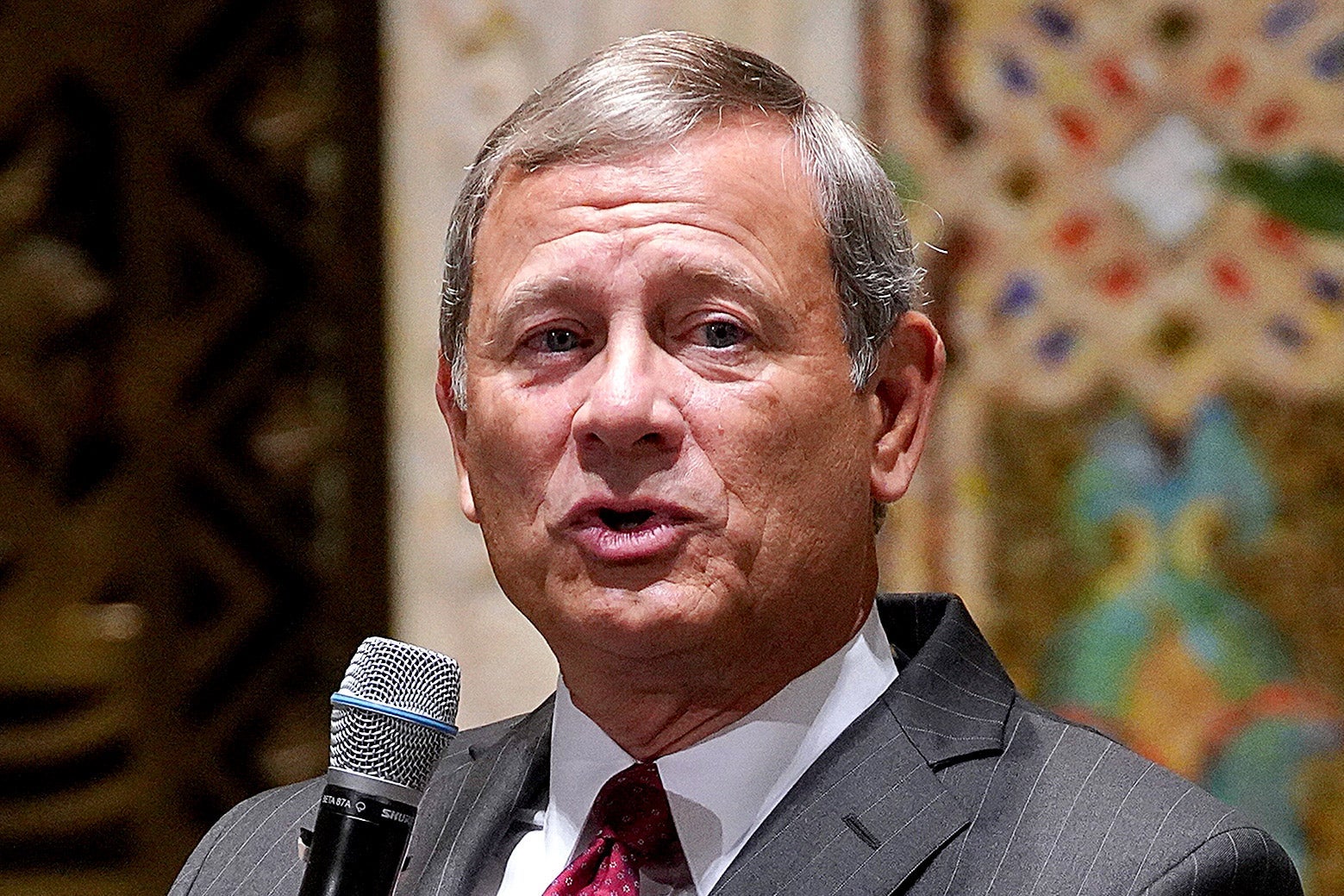Roberts speaking into a microphone.