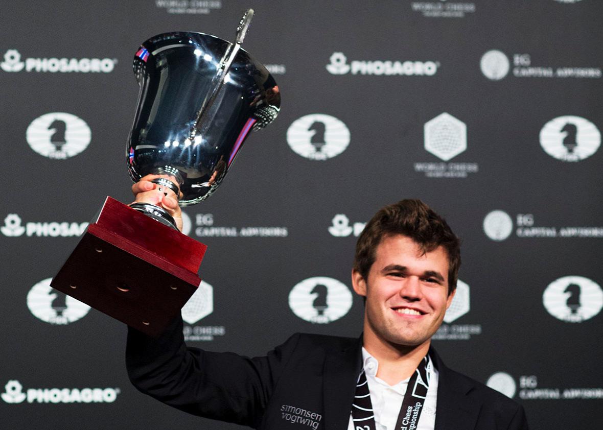 Magnus Carlsen, Norwegian chess grandmaster and current World Chess Champion, hods up his trophy during a closing ceremony after defeated Sergey Karjakin, Russian chess grandmaster, at the World Chess Championship on November 30, 2016 in New York. 