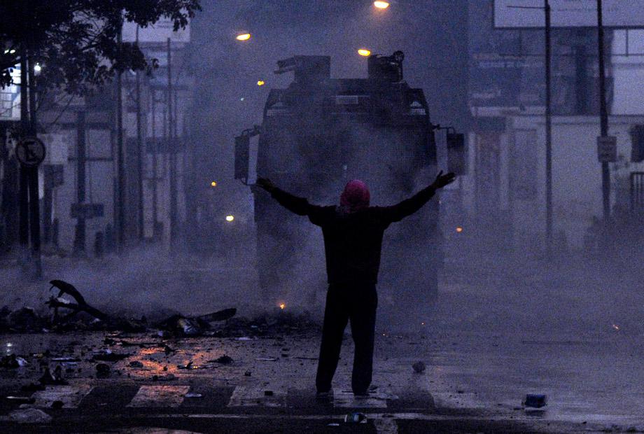 A protestor confronts riot policemen during an anti-government demo, in Caracas on February 19, 2014.