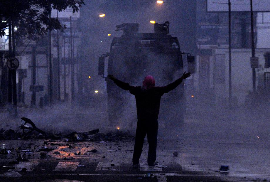 A protestor confronts riot policemen during an anti-government demo, in Caracas on February 19, 2014. 