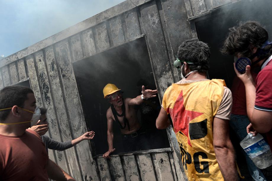 Demonstrators try to extinguish a fire in a container used for construction workers in Taksim Square in Istanbul on June 4, 2013.
