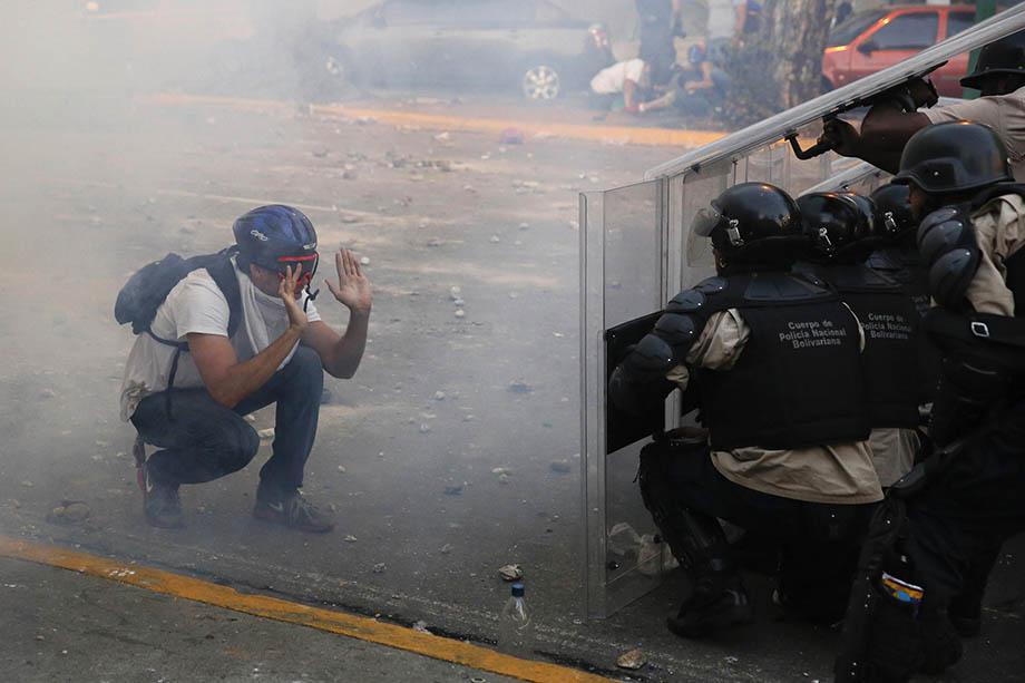 An opposition demonstrator confronts riot police during a protest against President Nicolas Maduro's government in Caracas.