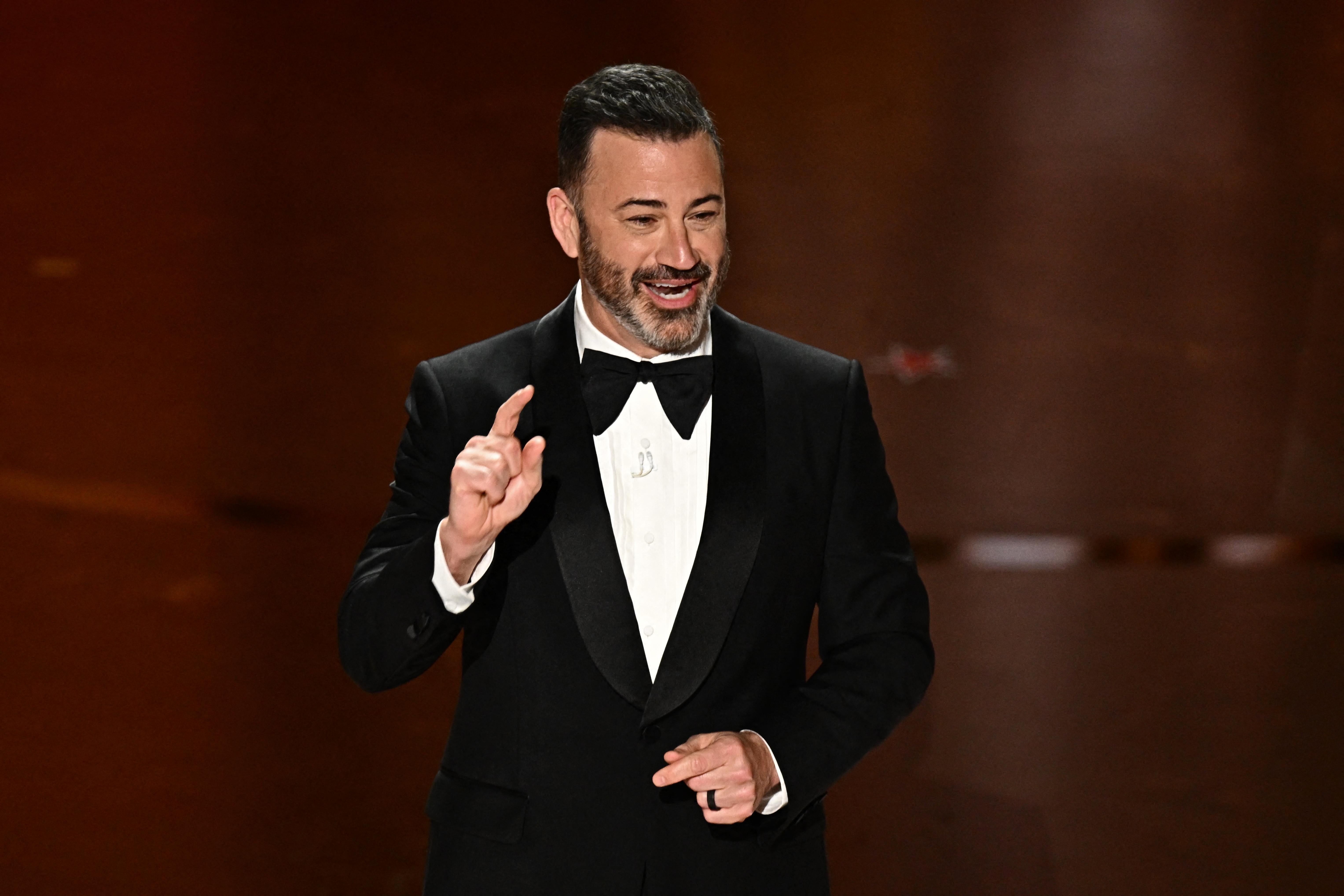 TV host Jimmy Kimmel speaks onstage during the 96th Annual Academy Awards at the Dolby Theatre in Hollywood, California on March 10, 2024. He holds one index finger up and smiles.