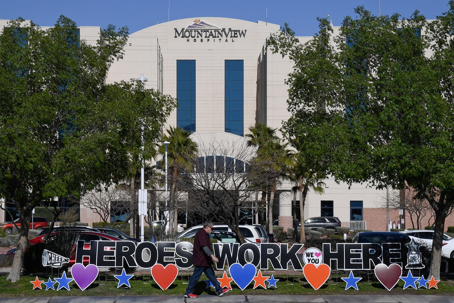 A man walks by a sign reading "Heroes work here" outside MountainView Hospital on April 2.