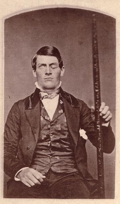 Cabinet-card portrait of Gage shown holding the tamping iron which injured him.