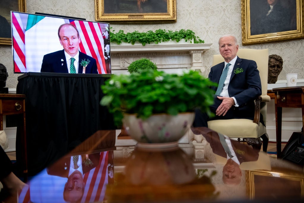 Biden sits in the Oval Office next to a large TV screen on which Martin appears.