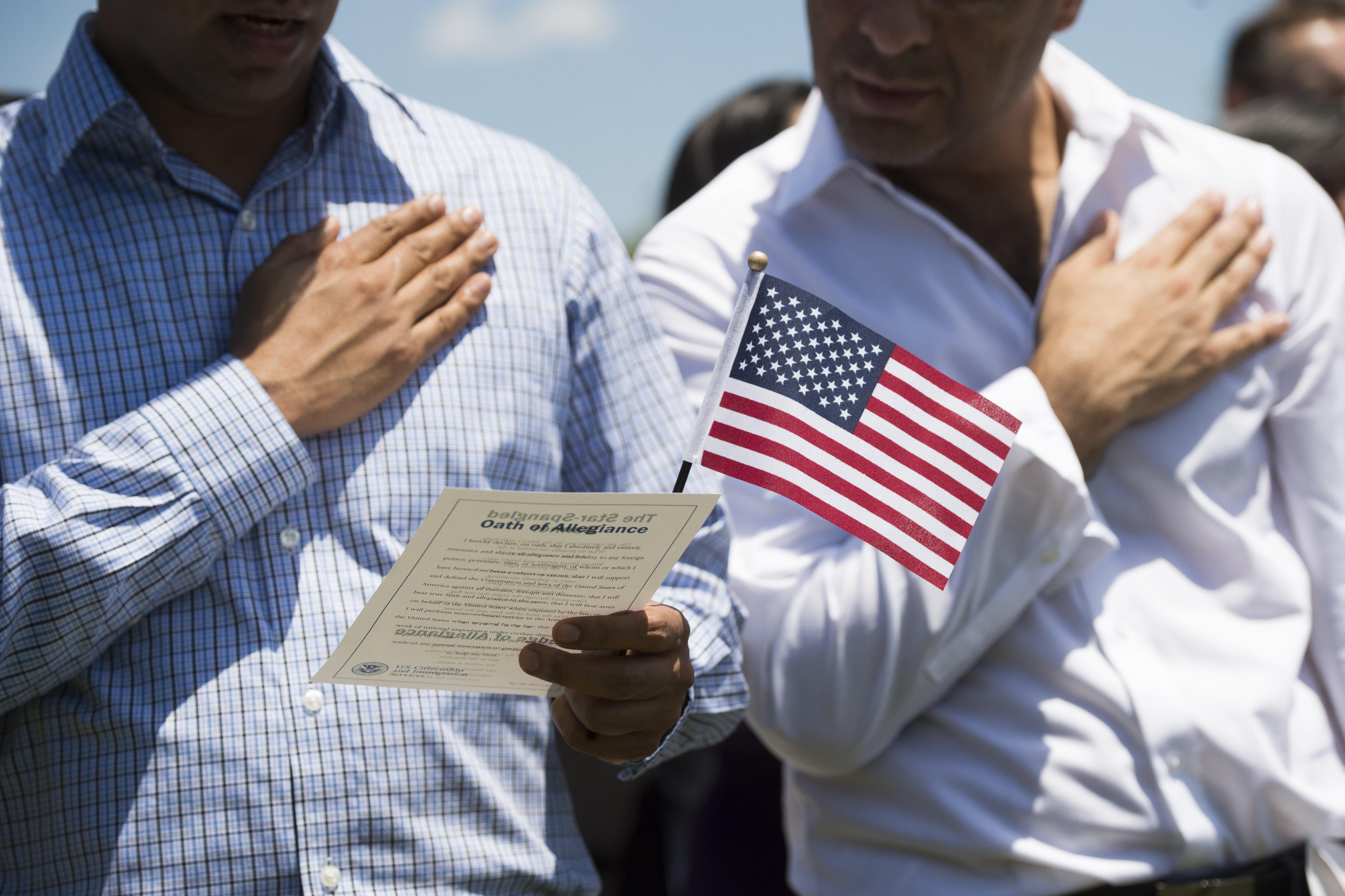 Newly sworn-in U.S. citizens recite the Pledge of Allegiance during a 2017 naturalization ceremony at Mount Vernon, Virginia.
