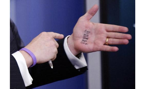 White House Press Secretary Robert Gibbs jokingly refers to a list written on his hand.