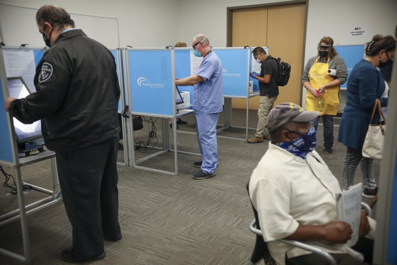 A handful of masked voters casting their early ballots.