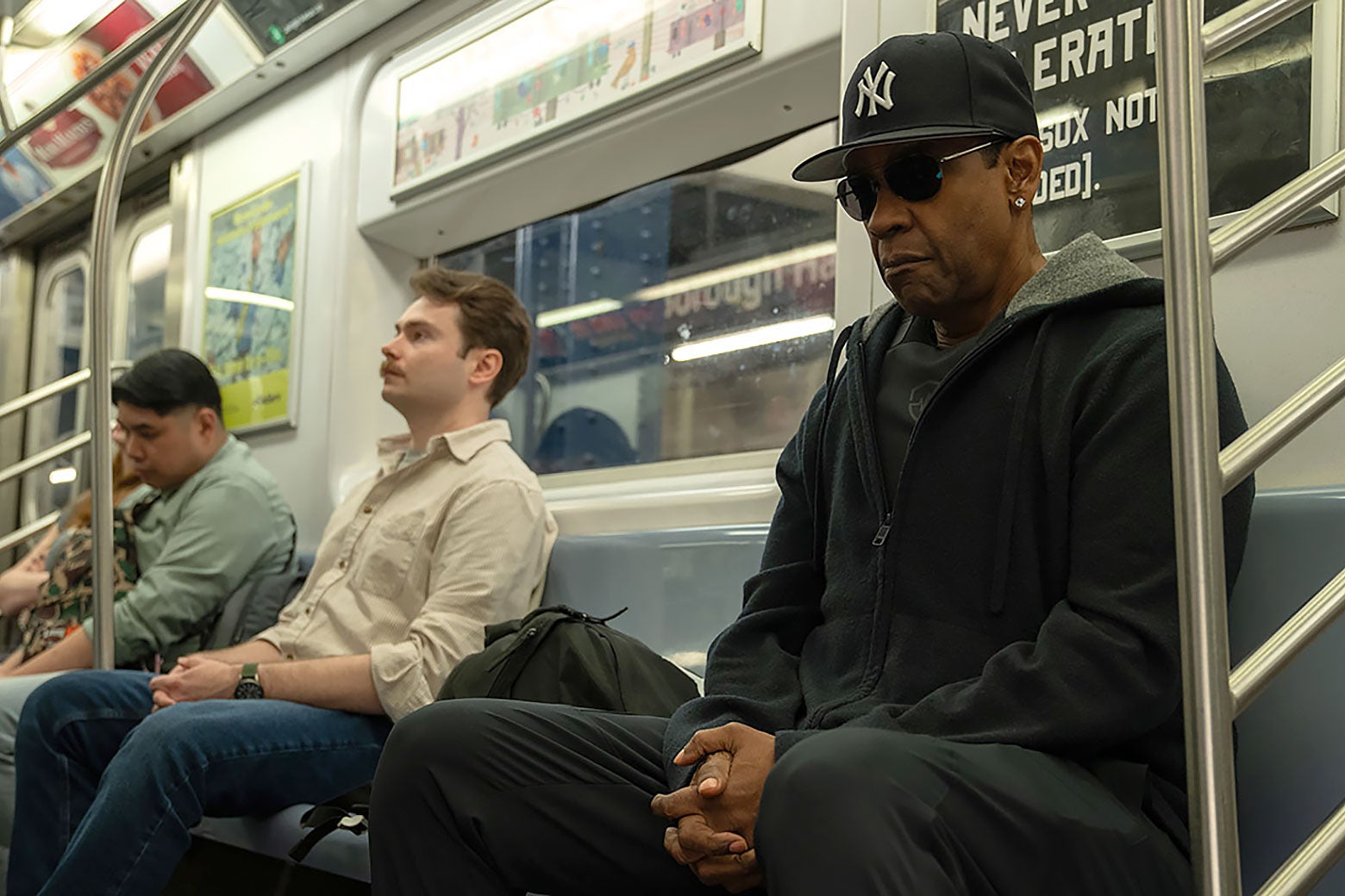 Denzel Washington, wyglądający incognito, w okularach przeciwsłonecznych i czapce Yankees, w metrze.