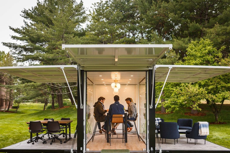 An indoor-outdoor working space amid some trees.