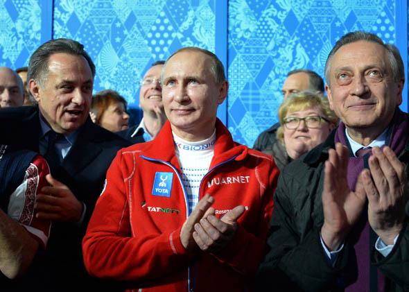 Russia's President Vladimir Putin applauds as team Russia won the gold medal during the Figure Skating Team Flower Ceremony at the Sochi Winter Olympics.