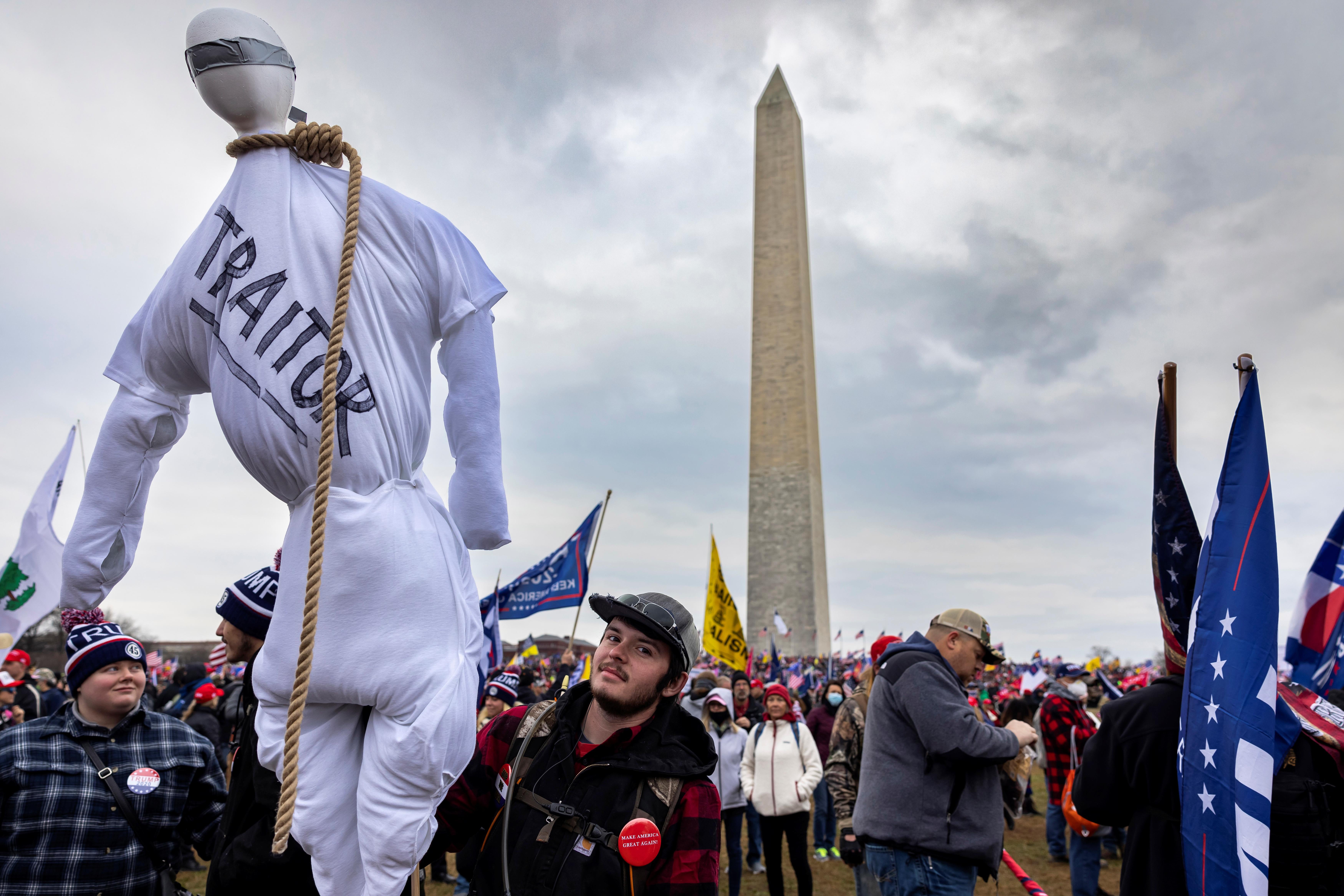 A mob of Trump supporters with the Washington Monument behind them, one carrying an effigy with the word "traitor" written on it and a noose around its neck.