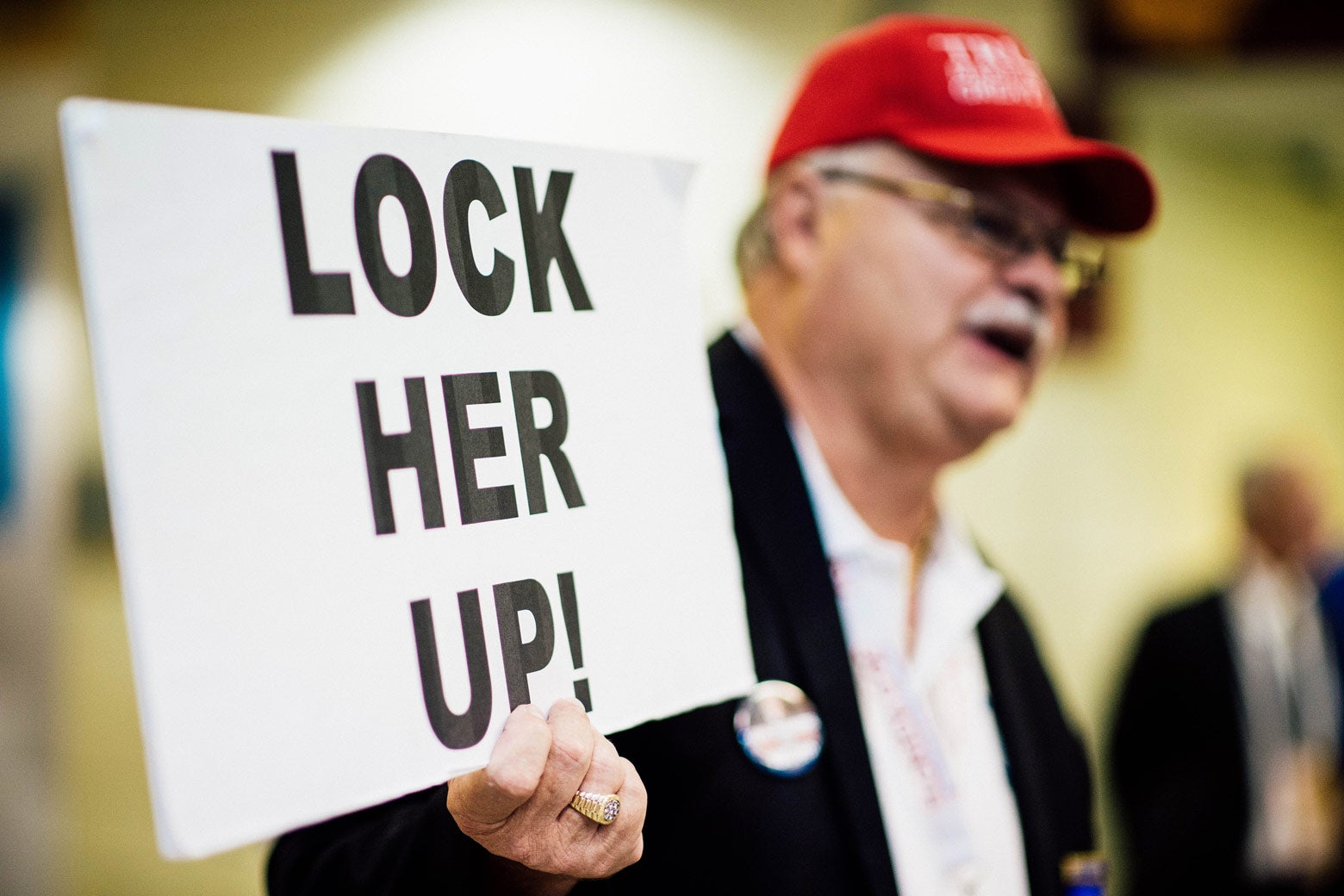 Florida delegate Henry Allen carries a Lock Her Up sign through the Quicken Loans Arena at the 2016 Republican National Convention in Cleveland on July 20, 2016. 