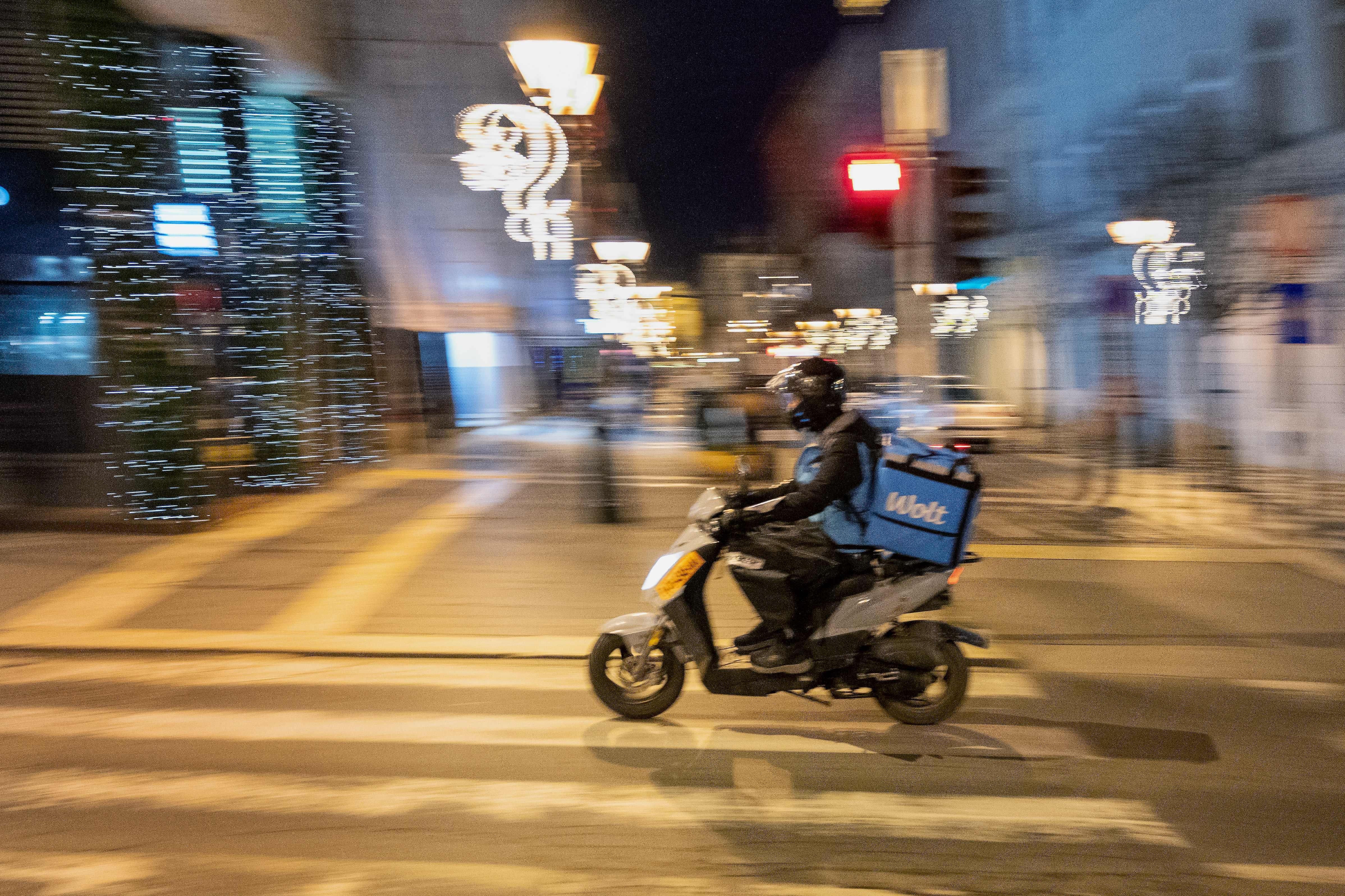 A food delivery bike courier blurred in motion through an empty street