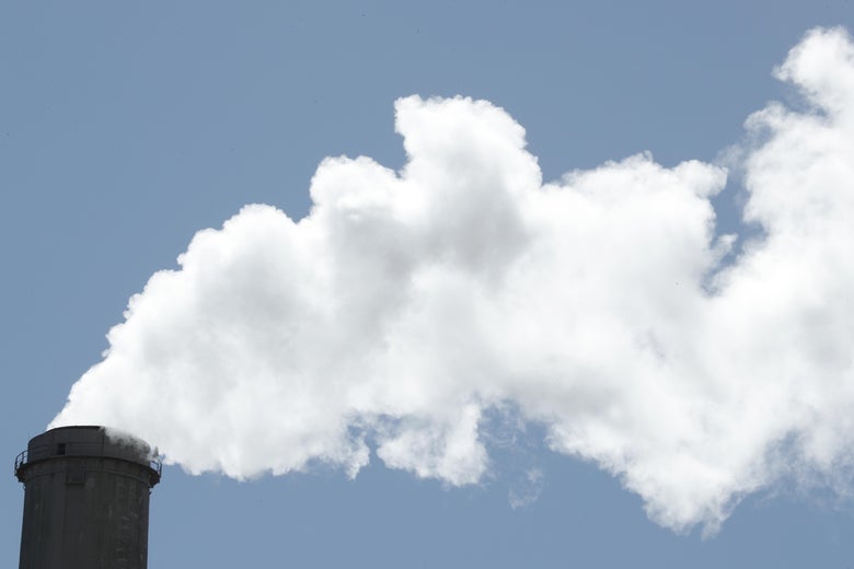 Emissions rise out of a large smoke stack on a clear day
